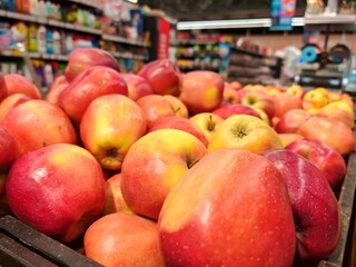 Juicy red apples in the supermarket. Red apples on a market stall. Yummy pile of apples in a market...