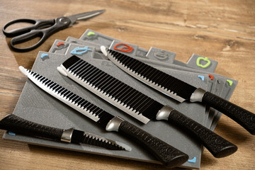 Selection of unique kitchen knives displayed on colorful cutting mats in a bright kitchen setting during a cooking session