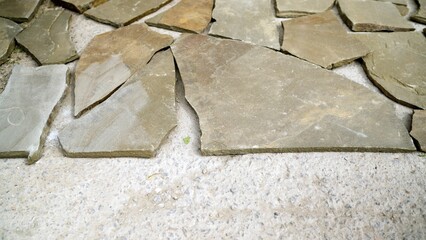 Stone pavement revealing intricate irregular shapes and natural textures, displaying nuanced surface details with organic gray and brown color variations