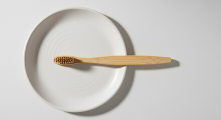 Minimalist presentation of wooden spoon with circular plate and clean shadow on white surface