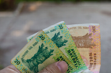 Moldovan money hand. Moldavian banknotes of 20 and 100 lei in hand. Moldovan LEI currency, close up. Making payments, inflation and economic situation concept