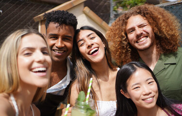 Group of cheerful multi-ethnic friends enjoying a summer day together outdoors