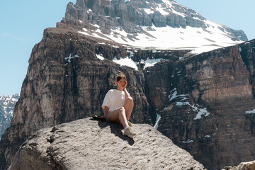 Woman sitting on large rock