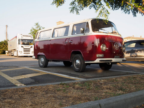 Classic Volkswagen T2 camper van parked in a lot by Chiaravalle della Colomba Abbey in Italy during the Corpus Domini feast