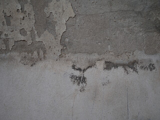 Weathered concrete surface displaying aged deterioration, textural patterns emerging from time's...