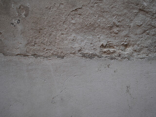 Weathered concrete surface displaying aged deterioration, textural patterns emerging from time's...