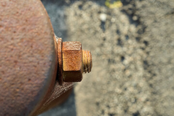 経年劣化で錆びたガードレールの支柱と蜘蛛の巣が付いたボルトのクローズアップ