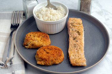 baked salmon served with crab cakes and rice