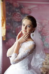 A woman in a white wedding dress is posing for a picture