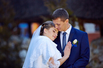 A bride and groom are hugging each other in a wedding photo
