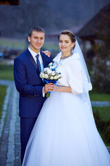 A bride and groom are posing for a picture in front of a building
