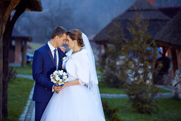 A bride and groom are standing together in front of a building