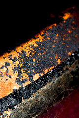 Close up of heavy black rust on a brass base of a kitchen sauce pan abstract background