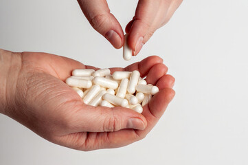 Hands holding white capsules, emphasizing medication, healthcare, and wellness concepts.