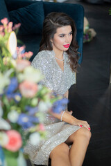 beautiful girl in a shiny dress with flowers