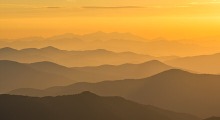 Obraz premium Layers of Golden Mountain Ridges at Sunset: A Serene and Majestic Vista