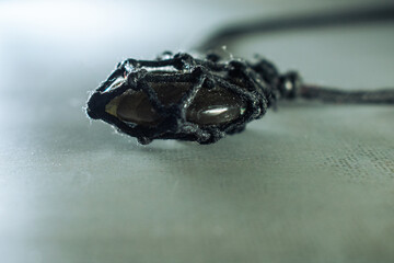 A striking labradorite pendant on a dark cord, showcasing its captivating flash on a textured background. Perfect for themes of unique jewelry, mystical accessories, and natural elegance.