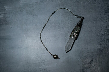 An ornate crystal quartz pendulum with a silver chain, ideal for divination, spiritual healing, and mindful practices. Perfect for esoteric, wellness, and mystical themes.
