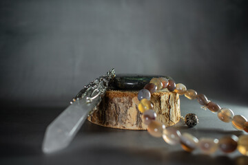 A powerful arrangement of a labradorite stone, crystal quartz pendulum, and agate bracelet, symbolizing balance, healing energy, and spiritual connection. Perfect for mystical and wellness themes.