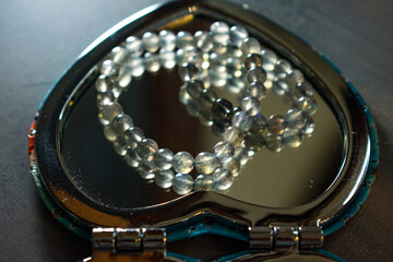 A beautiful labradorite bead bracelet reflected in a heart-shaped mirror, symbolizing inner beauty,...