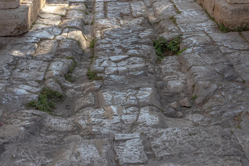The ancient Roman road is paved with large stone blocks. The road under the Arc de Triomphe in the...