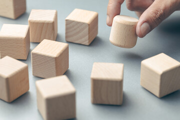 A hand puts a round block among cubes, business positioning, brand differentiation, and value in a...