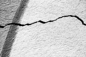 Big winding crack on old plastering wall. Copy space.  Black and white photo. Selective focus.