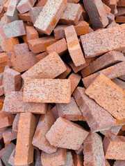 Brick stacked background texture. Pile of red bricks on a construction site. 