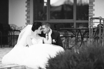 A bride and groom are walking down a path, the bride is wearing a white dress and the groom is...