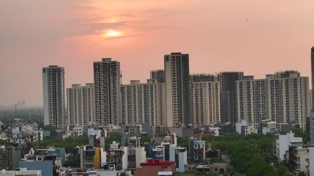 Aerial drone shot flying over Noida&rsquo;s roads and towers as the sun dips below the horizon.