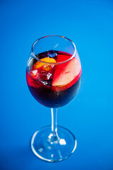 A tall glass filled with a colorful mix of fruits and ice, glistening under soft light