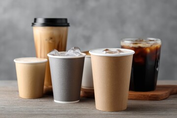 Refreshing iced coffee variations in stylish disposable cups on a rustic wooden table.
