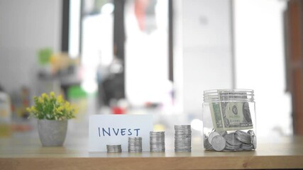 Investing and Saving Concept with Coins, Cash, and Written Sign