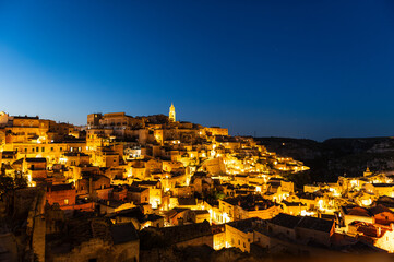 Les Sassi de Matera éclairées de nuit sous un ciel bleu foncé, région de Basilicate, Italie