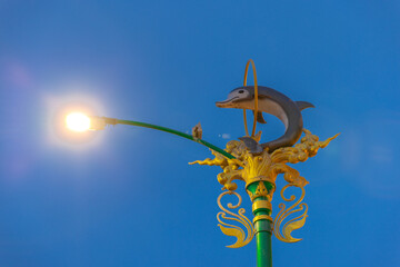 Light pole with a dolphin statue at Sunset Blue hour in Patong in the island of phuket Thailand 