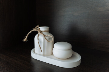 A beautiful vase and a decorative jar are elegantly positioned on a stylish tray resting on a...