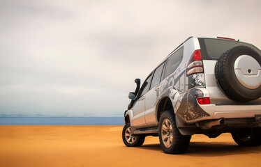 A powerful gray 4x4 SUV stands alone in the vast sandy terrain of the Namib Desert, ready for off-road travel, exploration, and endurance across one of Africa’s wildest landscapes. 