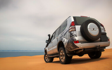 A powerful gray 4x4 SUV stands alone in the vast sandy terrain of the Namib Desert, ready for off-road travel, exploration, and endurance across one of Africa’s wildest landscapes. 