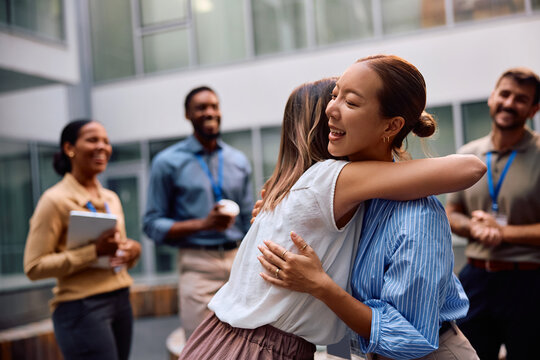 Female entrepreneurs embracing while celebrating their business success at work. - Powered by Adobe