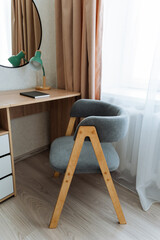 In a cozy room, there is a chair positioned directly in front of a desk, making it a perfect spot...