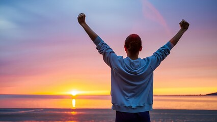 Woman celebrates success at sunset beach with arms raised, embodying freedom and accomplishment against a vibrant sky.