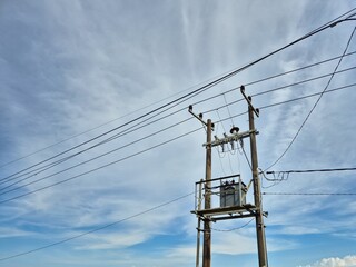 Rural Power Transformer Mounted on Utility Pole Under Blue Sky