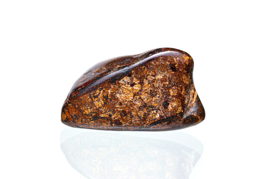 Bronzite gemstone on white background (pyroxene group minerals)(selective focus)
