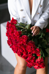 beautiful mulatto woman with a large bouquet of scarlet roses