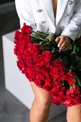 beautiful mulatto woman with a large bouquet of scarlet roses