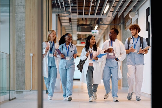 Multiracial group of happy student doctors going on lecture at university. - Powered by Adobe