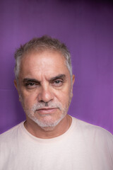 Obraz premium Gray-haired man between 50 and 60 years old with a serious look. An adult with a worried expression.