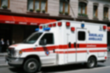 Blurry photo of an ambulance passing smoothly on a city road.