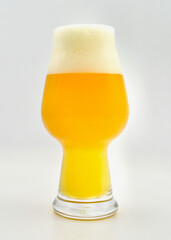 A glass of hazy IPA beer isolated against a white background. 