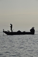 Angler fishing at sunrise in a boat
